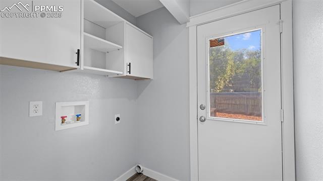 562 Blossom Field Road Fountain, CO 80817 - Photo 18 of 41 Laundry room featuring cabinet space, washer hookup, wood finished floors, and electric dryer hookup