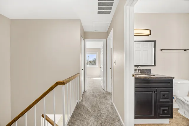 a view of a hallway to a livingroom with furniture