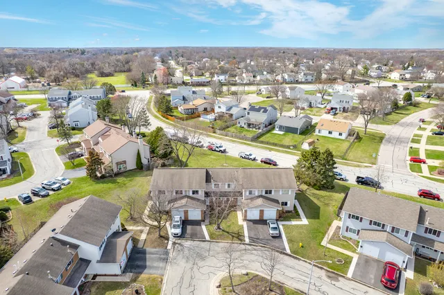 an aerial view of a city with lots of residential buildings ocean and mountain view in back