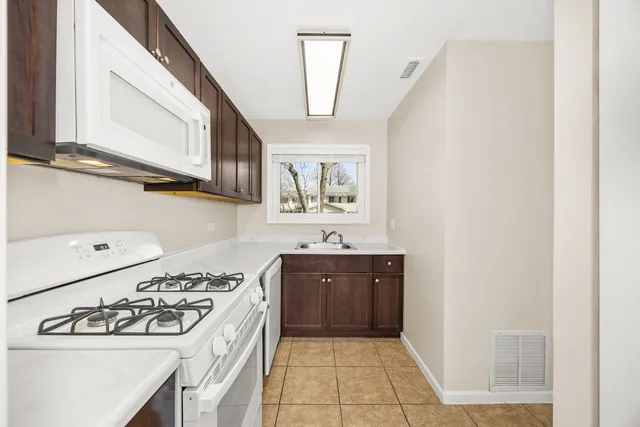 a kitchen with a stove sink and cabinets