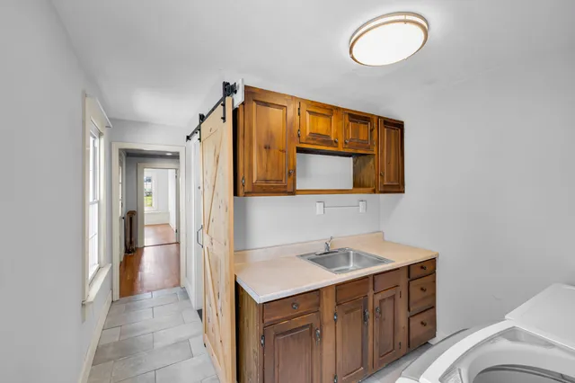 a view of empty room with window and wooden floor