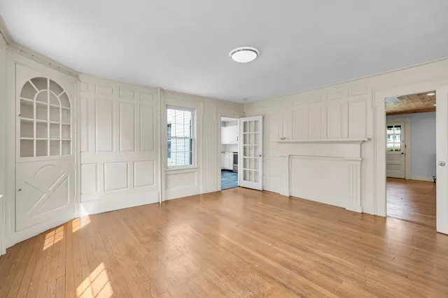 a view of empty room with wooden floor and windows