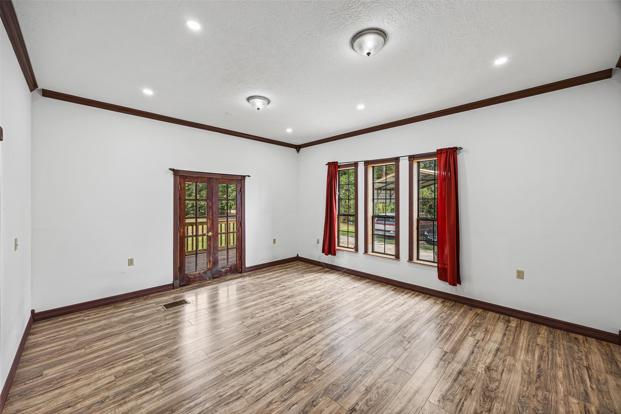 7 Northwood Country Road Huffman, TX 77336 - Photo 11 of 50 a view of an empty room with wooden floor and windows
