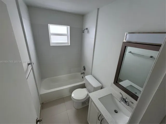 a bathroom with a granite countertop toilet a sink and a bathtub