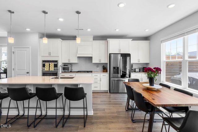 a dining room with furniture a chandelier and wooden floor