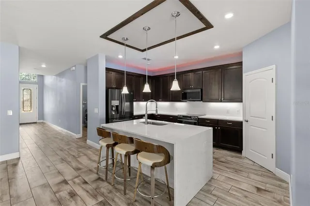 a kitchen with stainless steel appliances kitchen island a cabinets and wooden floor