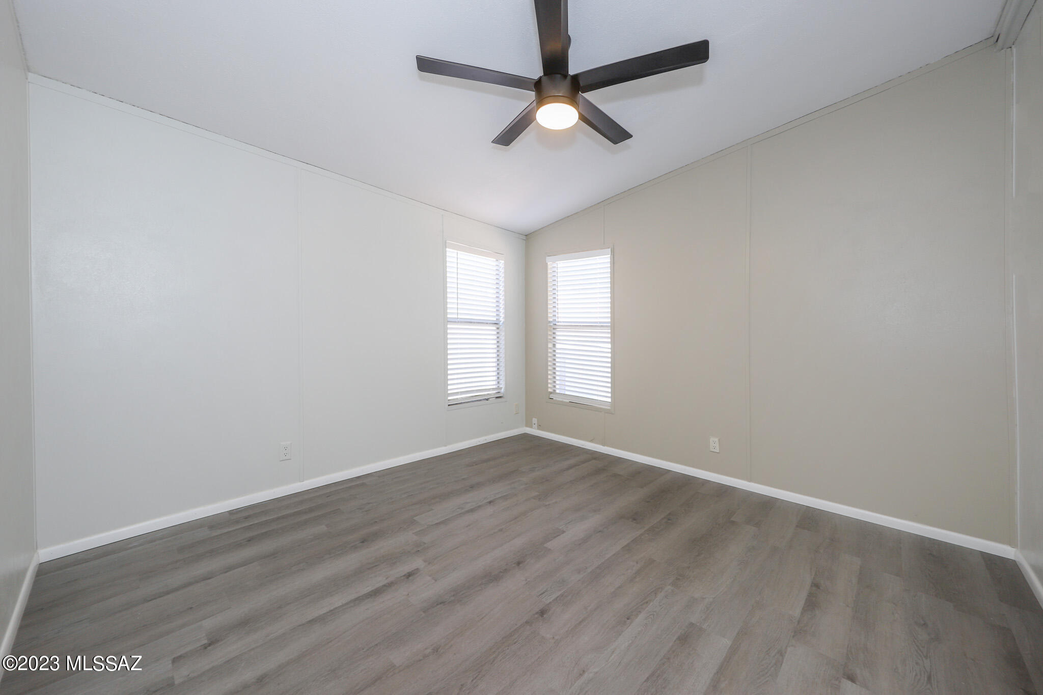 55 East King Road Tucson, AZ 85705 - Photo 19 of 26 an empty room with wooden floor fan and windows