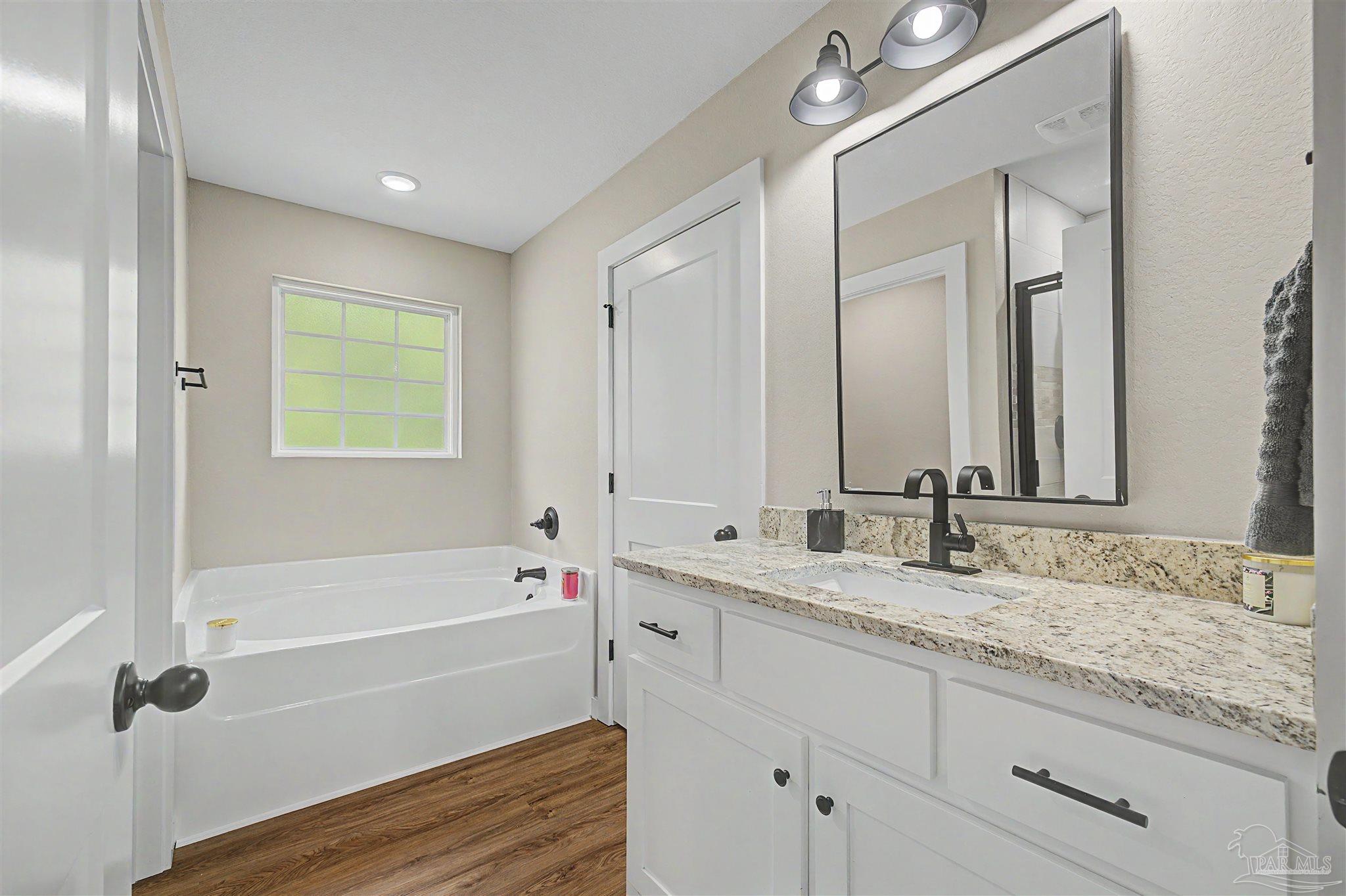 2549 Ten Mile Road Pace, FL 32571 - Photo 31 of 46 a bathroom with a granite countertop sink mirror and a bathtub