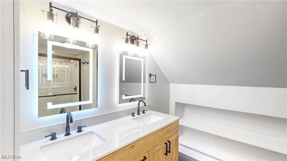 2978 Long Road Uniontown, OH 44685 - Photo 35 of 40 Bathroom featuring double vanity, a stall shower, and vaulted ceiling