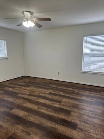 a view of empty room with window and ceiling fan