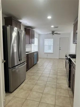 a kitchen with stainless steel appliances granite countertop a refrigerator and a stove top oven
