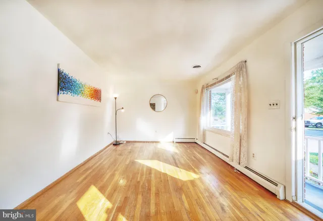 a view of empty room with window and wooden floor