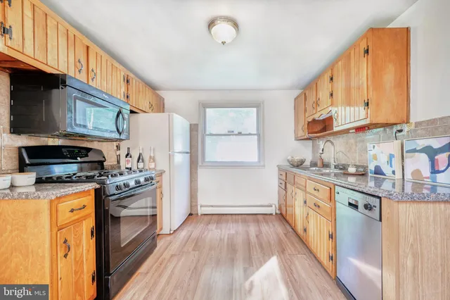 a kitchen with stainless steel appliances granite countertop a stove a sink and a refrigerator