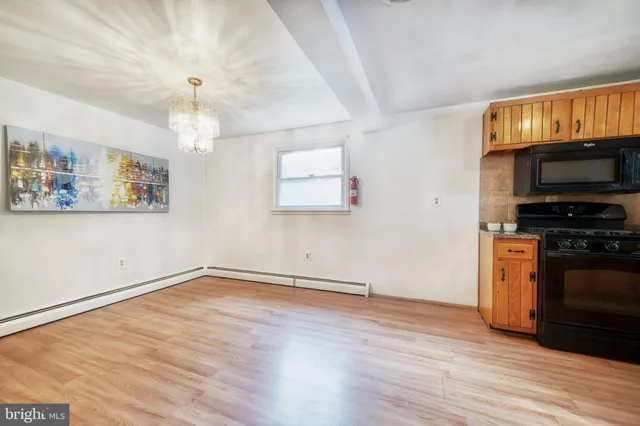 a view of a kitchen with wooden floor a sink a refrigerator and window