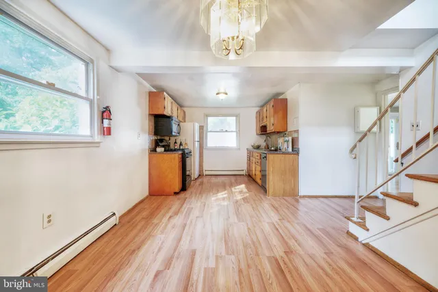 a view of a kitchen with wooden floor electronic appliances and windows