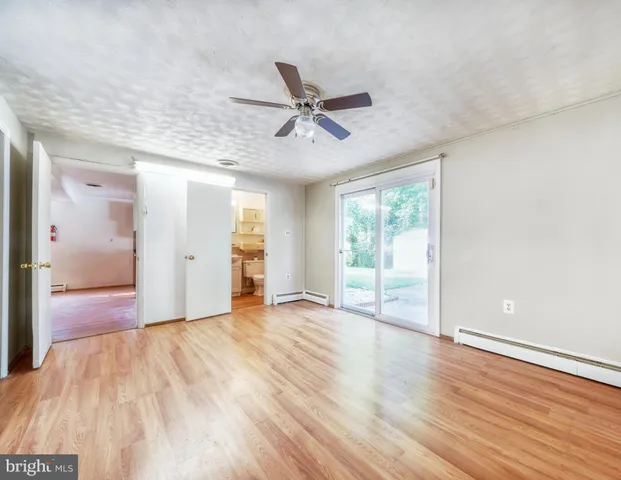 a view of a livingroom with wooden floor and a ceiling fan