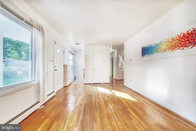 a view of a big room with wooden floor and windows