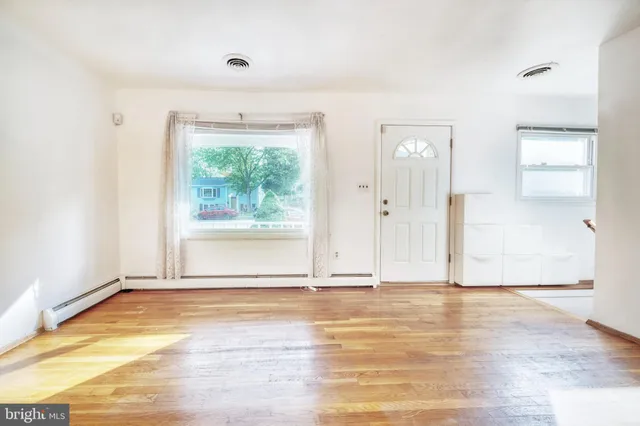a view of a room with wooden floor and a window