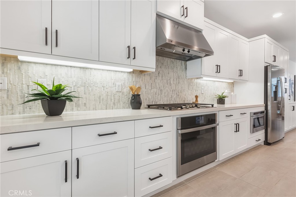 285 Lodestar Tustin, CA 92782 - Photo 13 of 40 a kitchen with stainless steel appliances white cabinets and a stove