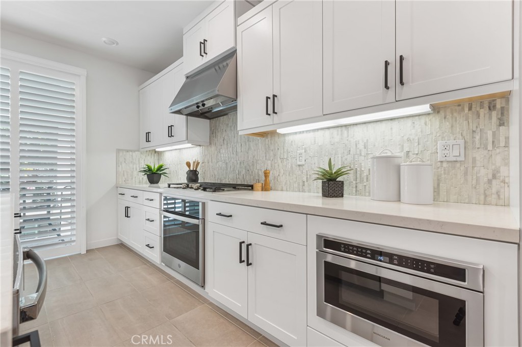 285 Lodestar Tustin, CA 92782 - Photo 14 of 40 a kitchen with white cabinets and white appliances