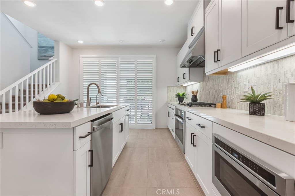 285 Lodestar Tustin, CA 92782 - Photo 16 of 40 a kitchen with stainless steel appliances a sink stove and cabinets
