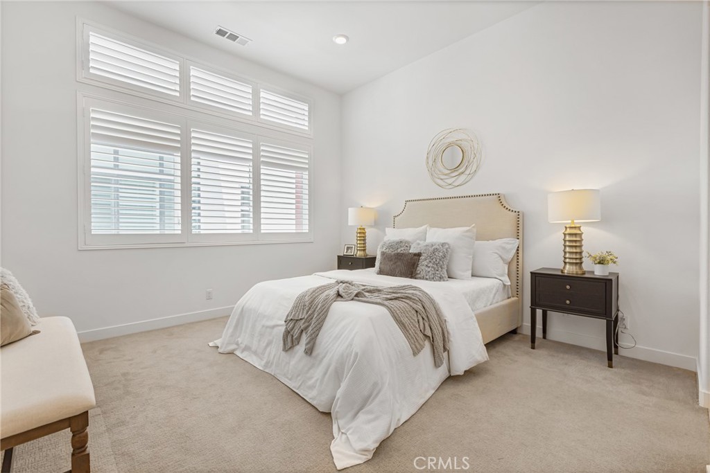 285 Lodestar Tustin, CA 92782 - Photo 24 of 40 a spacious bedroom with a bed and a table in it