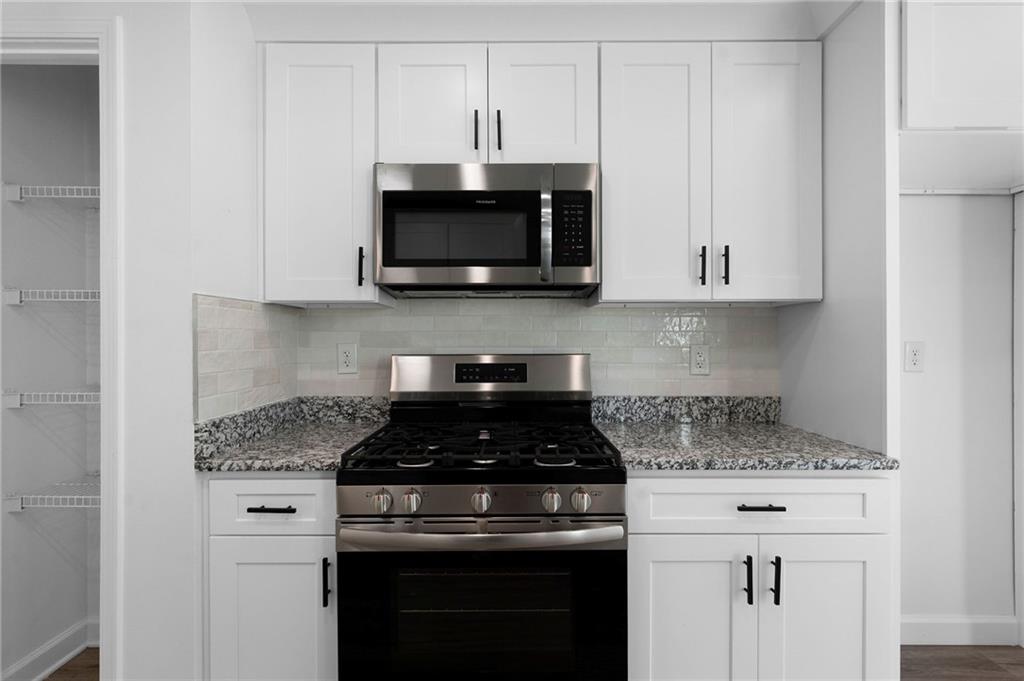 20 Mallet Pointe Street Northeast Cartersville, GA 30121 - Photo 11 of 37 a kitchen with white cabinets and black appliances