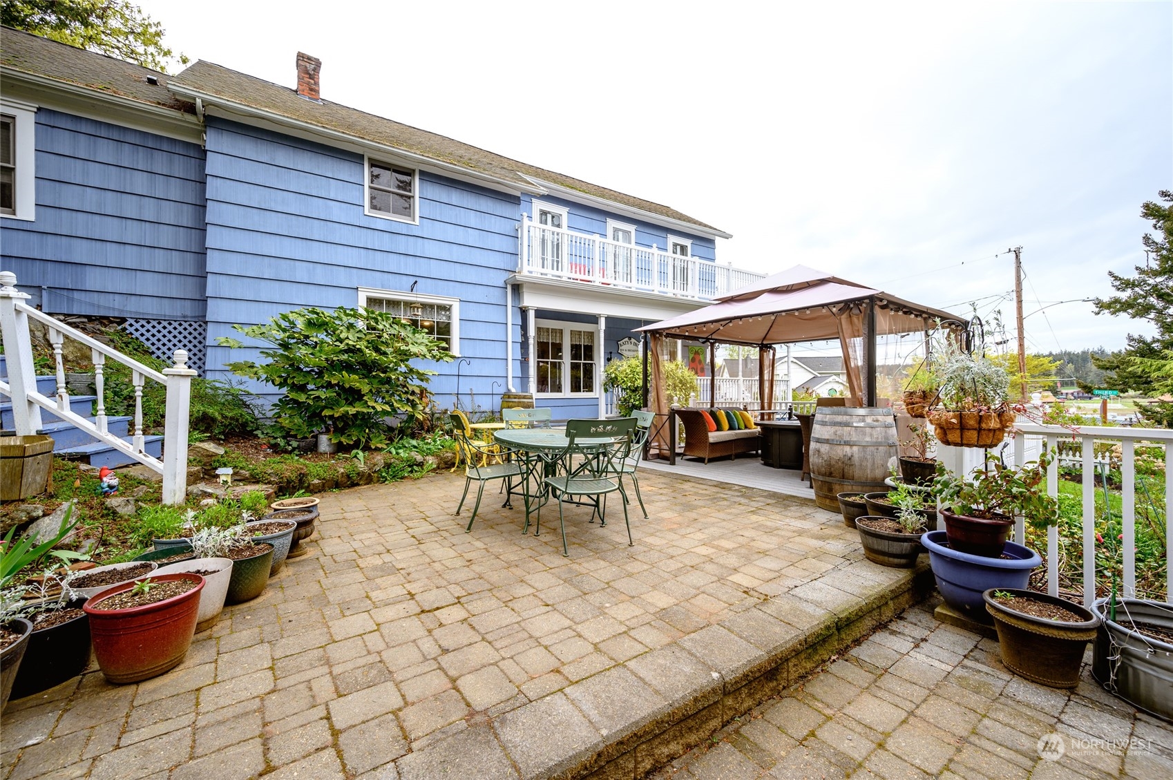 503 South 3rd Street La Conner, WA 98257 - Photo 37 of 39 a view of a patio with table and chairs potted plants and a fountain