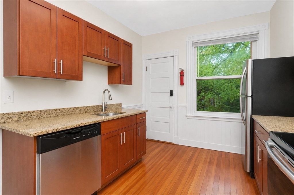 8 Colliston Road Boston, MA 02135 - Photo 15 of 40 a kitchen with stainless steel appliances granite countertop a sink stove and refrigerator