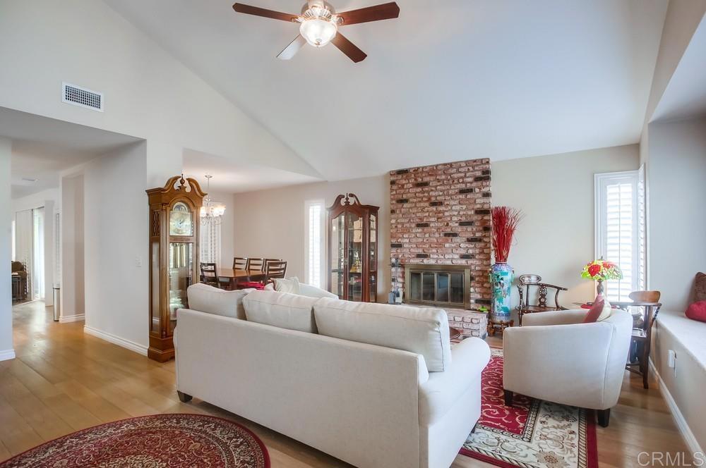 12705 Coachman Court Poway, CA 92064 - Photo 4 of 29 a living room with furniture a fireplace and a chandelier