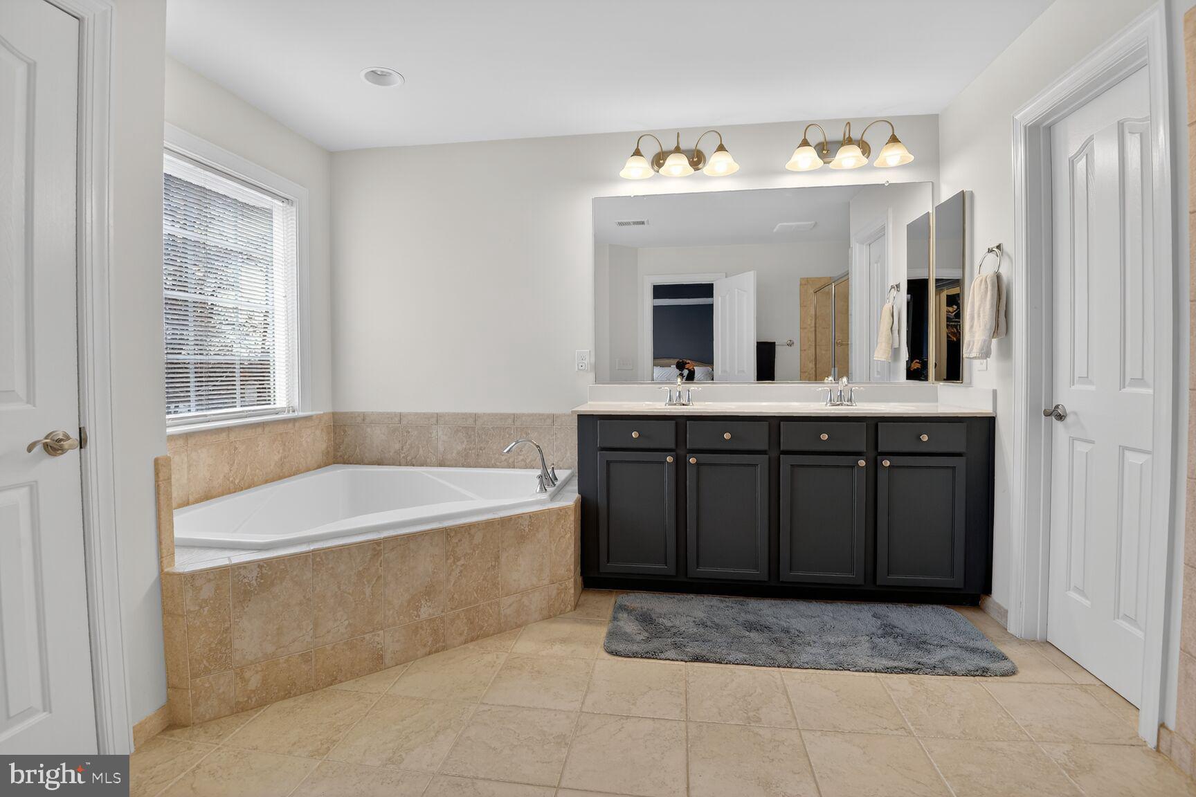 8808 Talbert Road Lorton, VA 22079 - Photo 29 of 52 a spacious bathroom with a tub sink and mirror