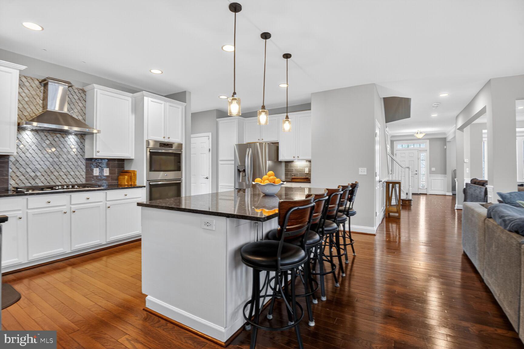 8808 Talbert Road Lorton, VA 22079 - Photo 10 of 52 a kitchen with stainless steel appliances granite countertop a stove a refrigerator a kitchen island a dining table and chairs with wooden floor