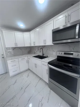 a kitchen with stainless steel appliances white cabinets and a stove top oven
