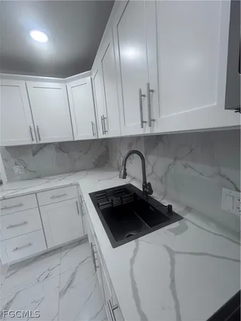 a kitchen with white cabinets and a sink
