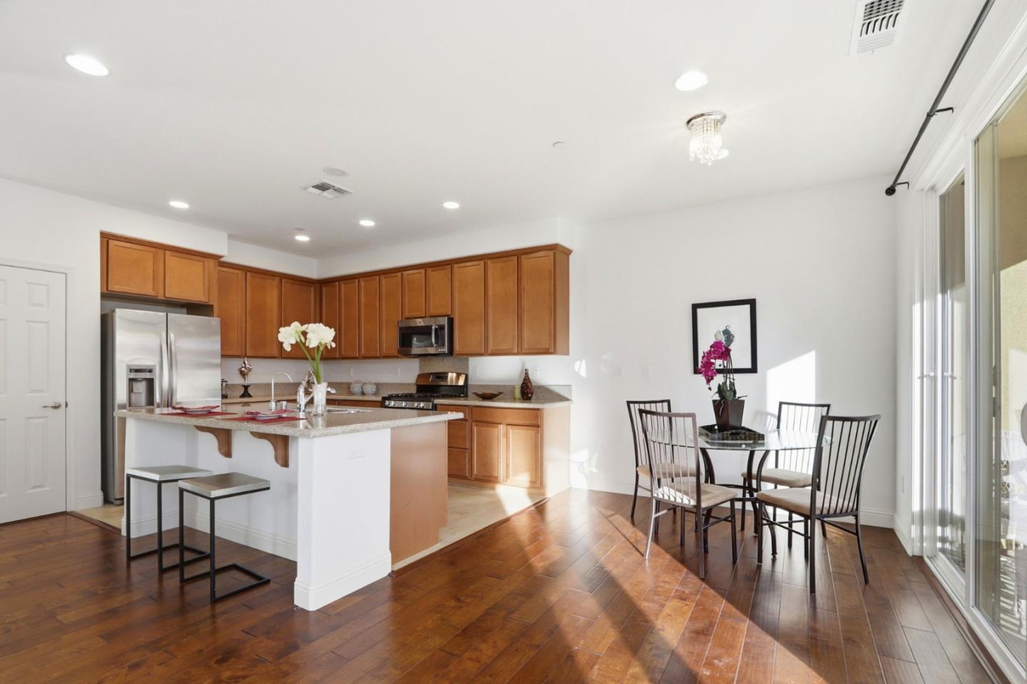 1550 Bleecker Street Milpitas, CA 95035 - Photo 8 of 35 a kitchen with stainless steel appliances a dining table chairs stove refrigerator and cabinets
