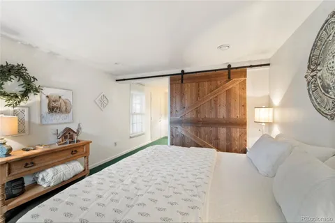 a bed room with a bed and three large window