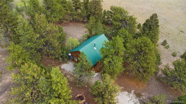 an aerial view of a house with a yard and tree s