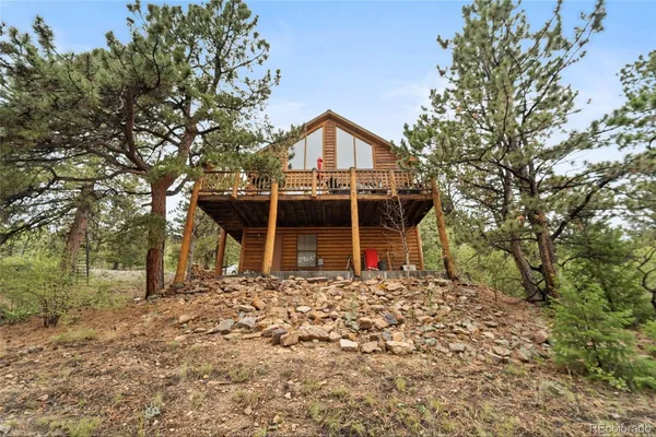 a view of a house with a yard and wooden fence