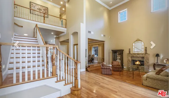 a living room with fireplace furniture and a rug