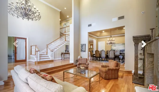 a living room with fireplace furniture and a chandelier