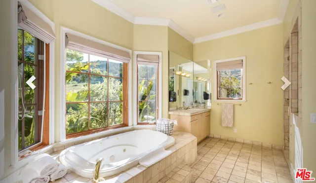 a bathroom with a granite countertop tub shower and sink