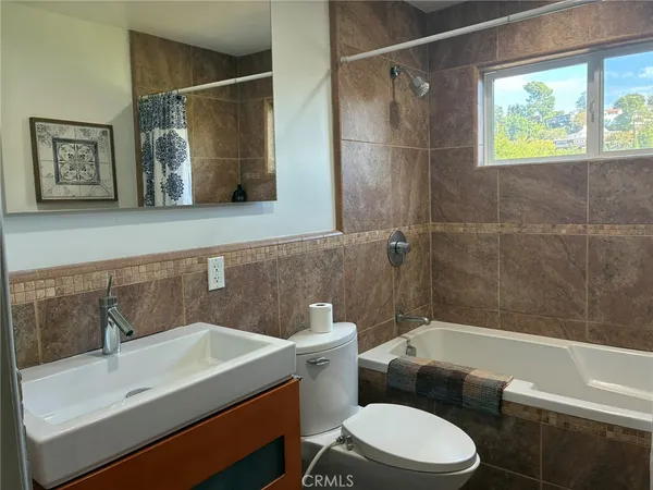 a bathroom with a sink mirror toilet and bathtub