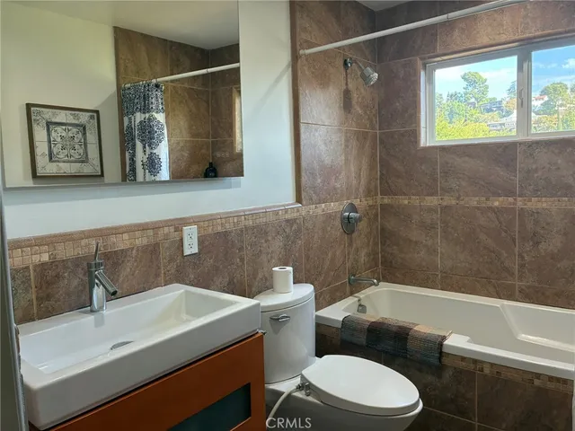 a bathroom with a sink mirror toilet and bathtub