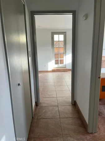 an empty room with mirror and entrance