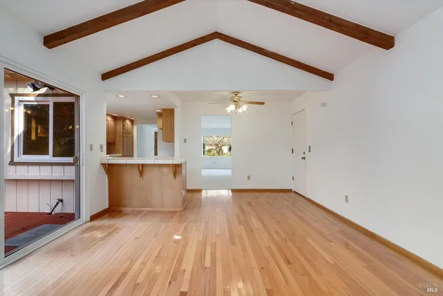 a view of a kitchen with wooden floor and a window