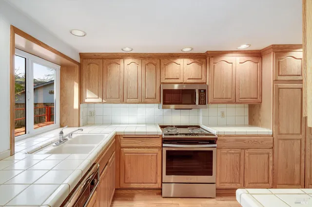 a kitchen with stainless steel appliances a stove sink and cabinets