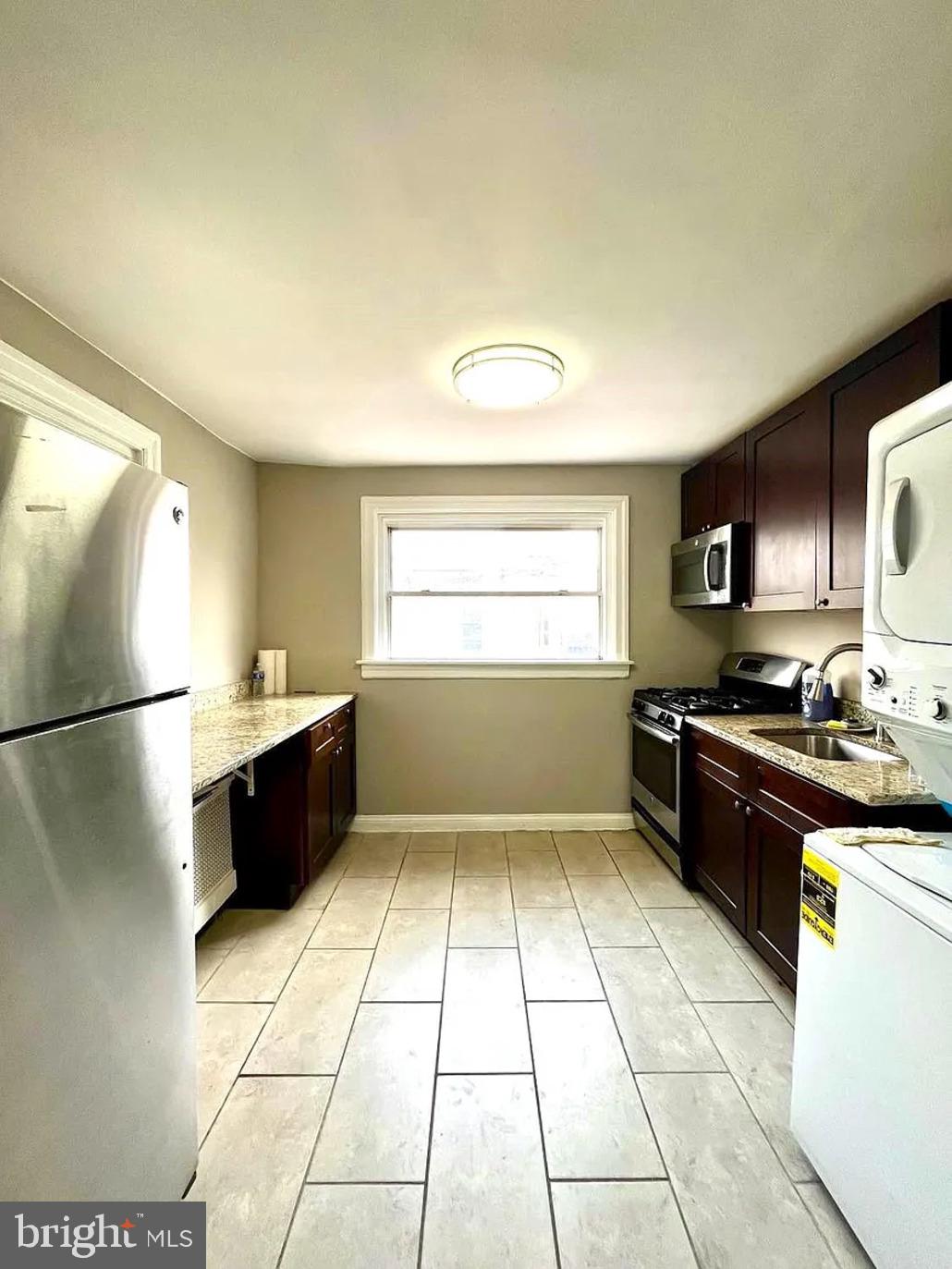 2127 Tasker Street, Unit 2 Philadelphia, PA 19145 - Photo 1 of 5 a kitchen with stainless steel appliances granite countertop a stove a sink and a refrigerator