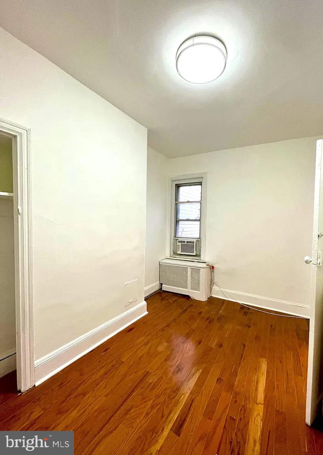 2127 Tasker Street, Unit 2 Philadelphia, PA 19145 - Photo 5 of 5 an empty room with wooden floor and windows