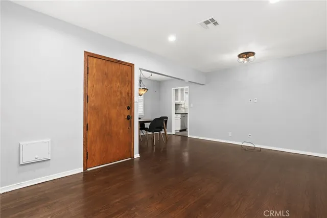 a view of empty room with wooden floor and windows