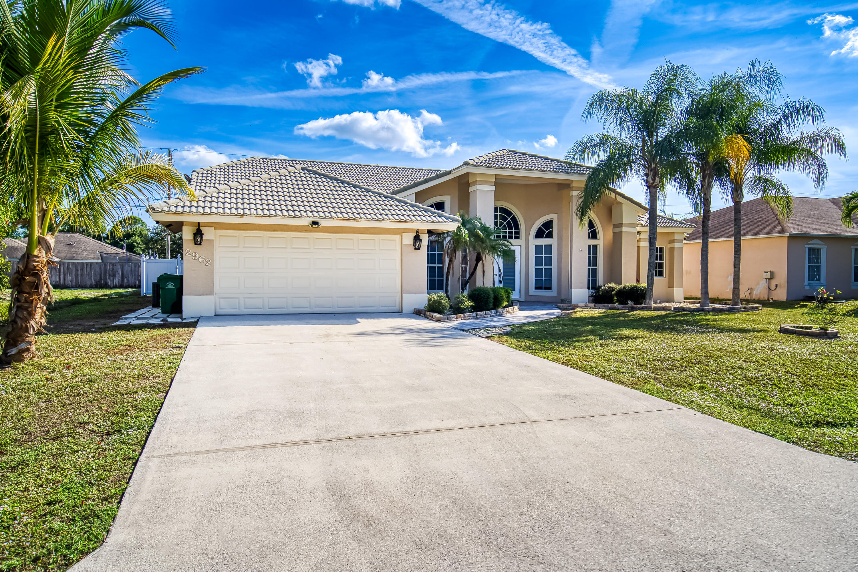 2962 Southwest Coastal Terrace Port St. Lucie, FL 34953 - Photo 1 of 59 a front view of a house with a yard and palm trees